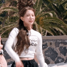 a woman wearing a white crop top that says lover on it