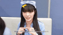 a woman wearing a blue headband with a hand on it