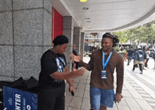 a man talking to another man in front of a blue box that says " enter "