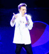 a man singing into a microphone in front of a pepsi logo