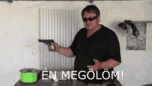 a man is holding a gun in front of a sign that says en megolom