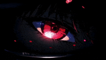 a close up of a person 's red eye with a light coming out of it in the dark .