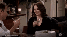 a man and a woman are sitting at a table with a martini .