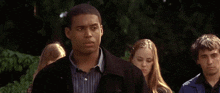 a man and a woman are hugging each other in a park