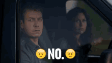 a man and a woman are driving a car and the man is saying no .
