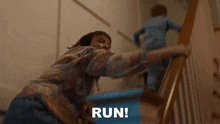 a woman is holding onto a railing while a child climbs the stairs .