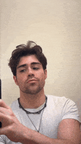 a man with a beard is taking a selfie with his phone