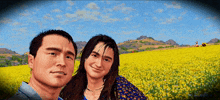 a man and a woman are posing in a field of yellow flowers