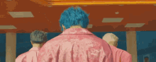 a man with blue hair wearing a pink jacket