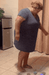 a woman in a striped dress stands on a scale