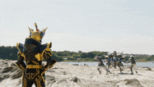 a man in a black and gold costume stands in front of a group of robots
