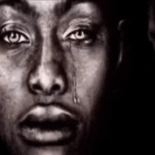 a close up of a person 's face with a tear coming out of their eye
