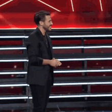 a man in a suit is standing in front of a microphone on a stage