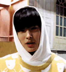 a close up of a person wearing a white hoodie and a yellow sweater