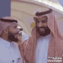 a couple of men are standing next to each other and smiling .