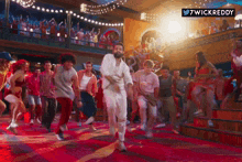a group of people are dancing in a room with a 7wickreddy logo