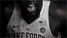 a black and white photo of a basketball player with his mouth open