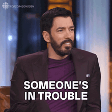 a man with a beard and a suit says someone 's in trouble