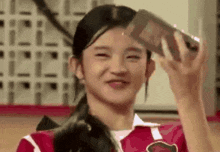 a young girl is smiling while holding a bottle of milk in her hand .