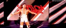 a wrestler is standing in front of a large screen with the word bullet on it .