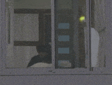 a person is sitting in a chair looking out a window