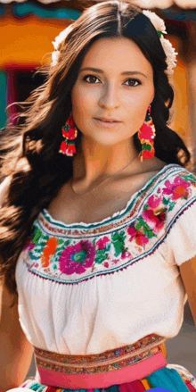 a woman wearing a white top with floral embroidery