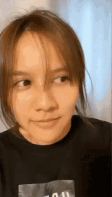 a close up of a woman wearing a black shirt with the word all on it