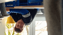 a young man wearing a puma shirt is upside down