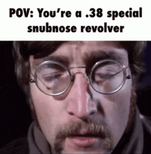 a man with glasses and a beard has a .38 special snubnose revolver