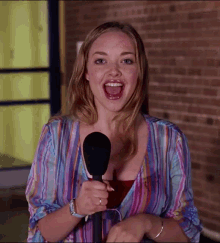 a woman holding a microphone with her mouth wide open