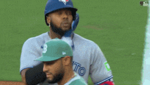 a baseball player wearing a blue jays uniform is standing on the field