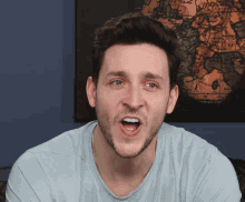 a man is making a funny face in front of a map of the world