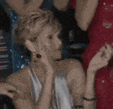 a woman in a white dress is dancing with a red dress in the background