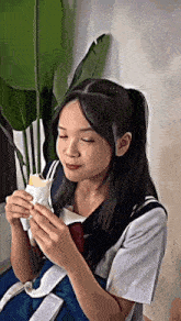 the girl is wearing a school uniform and eating a sandwich .
