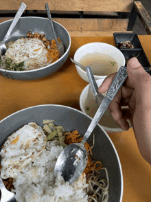 a person is holding a spoon over a bowl of food