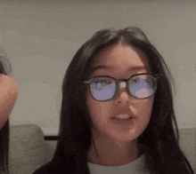 a girl wearing glasses looks at the camera