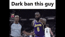 a basketball player in a purple lakers jersey is standing next to a referee .