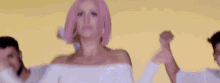 a woman with pink hair is dancing with a group of men .