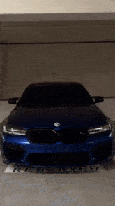 a blue bmw is parked in a reserved parking lot