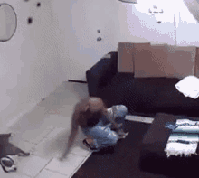 a person is kneeling on the floor in a living room with a couch