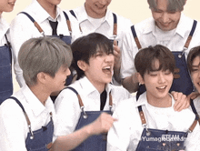 a group of young men are wearing aprons and laughing together .