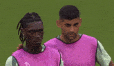 a man with dreadlocks is standing next to another man