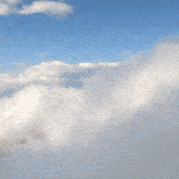 a person is standing in the clouds with a blue sky behind them