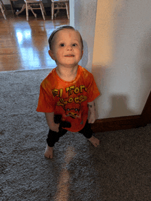 a little boy wearing an orange shirt that says el toro loco on it