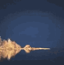 a fireworks display is reflected in a lake at night