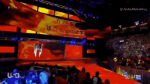 a crowd of people are watching a wrestling match with the word raw on the screen