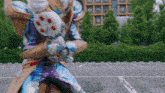 a person in a costume is standing in a parking lot holding a gun