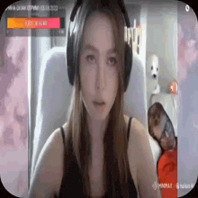 a woman wearing headphones is sitting in front of a computer monitor .