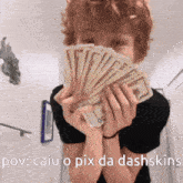 a person holding a bunch of money in front of their face