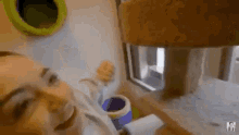 a woman is playing with a cat tree in a room .
